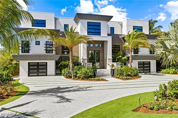 a front view of a house with garden and plants