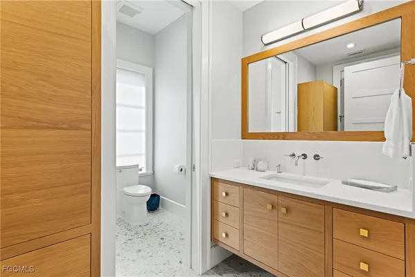 a bathroom with a granite countertop sink mirror and toilet
