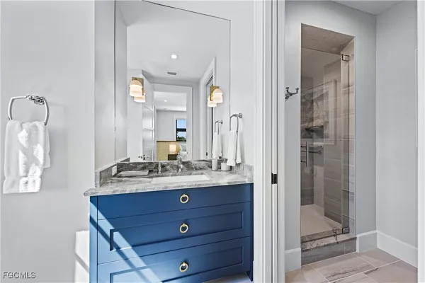 a bathroom with a sink vanity granite shower and a mirror