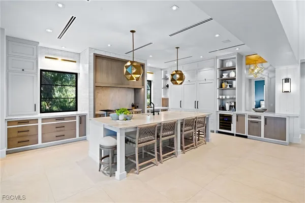 a kitchen with stainless steel appliances kitchen island granite countertop a table chairs sink and cabinets