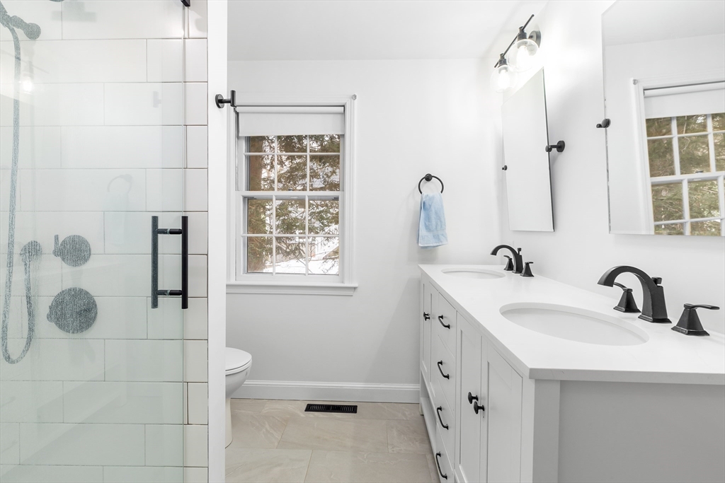 14 Griscom Road Sudbury, MA 01776 - Photo 9 of 32 a bathroom with a double vanity sink a toilet and a shower