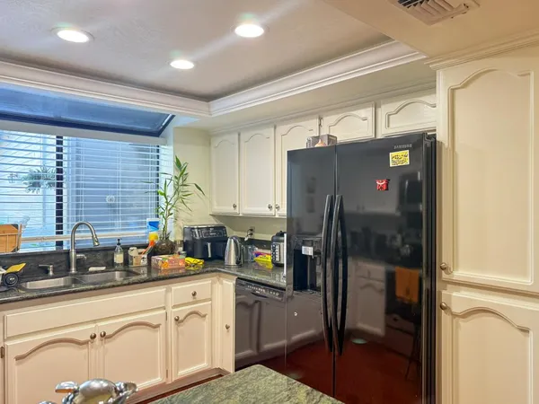 a kitchen with stainless steel appliances granite countertop a refrigerator and a sink