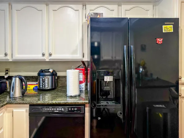 a kitchen with granite countertop a refrigerator and stove