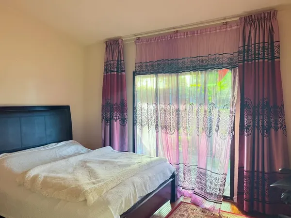 a bed sitting in a bedroom next to a window