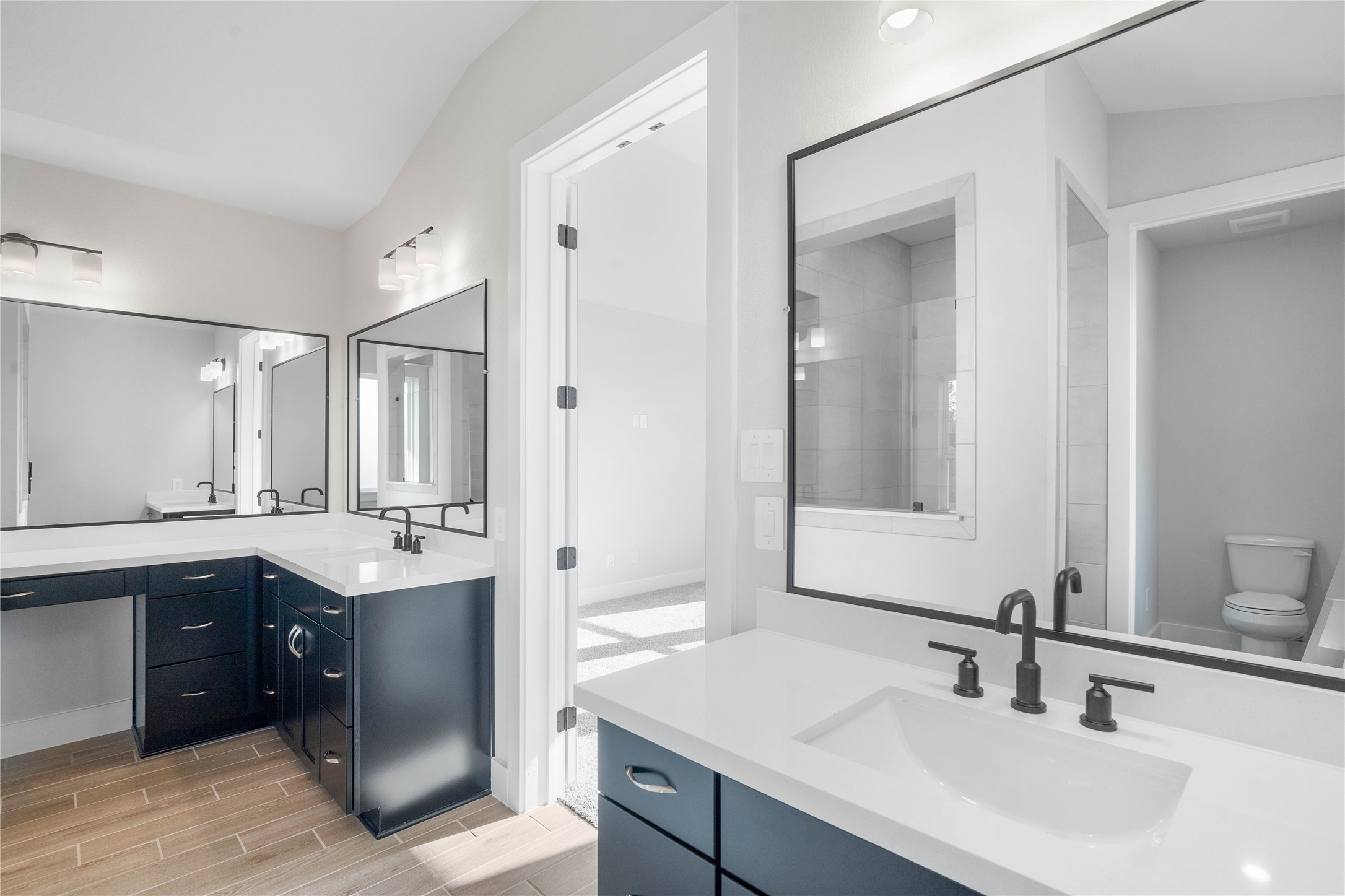2114 Rowl Street Montgomery, TX 77316 - Photo 34 of 50 This stunningly updated primary bathroom is truly move-in ready! It features gorgeous dual vanity cabinetry with light countertops, large framed mirrors, soaring ceilings, custom paint, and sleek modern fixtures.