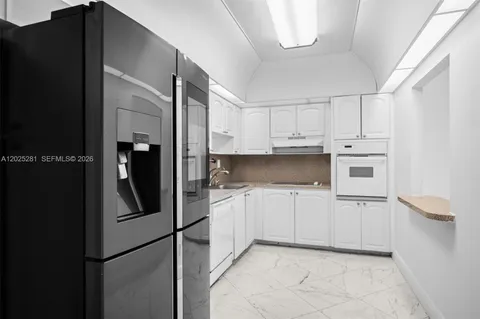 a kitchen with stainless steel appliances granite countertop a refrigerator and a sink