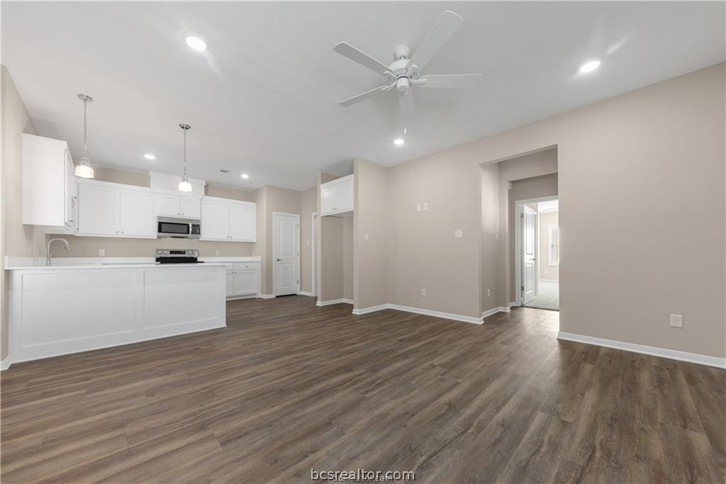 1249 Storm Row Lane Bryan, TX 77803 - Photo 6 of 20 an empty room with wooden floor and kitchen view
