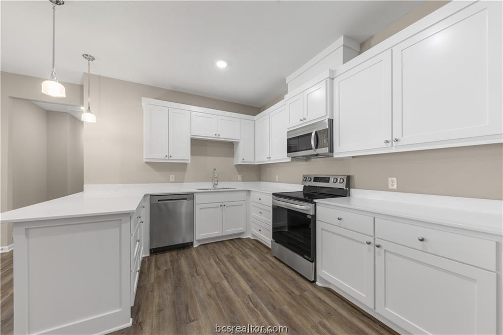 1249 Storm Row Lane Bryan, TX 77803 - Photo 8 of 20 a kitchen with granite countertop white cabinets and white appliances