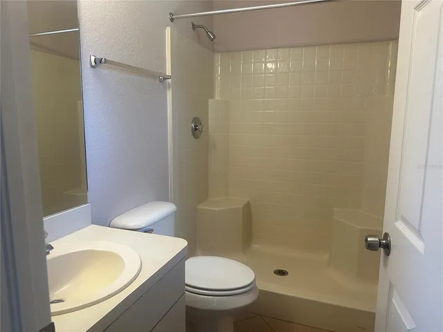 a white toilet sitting next to a bathroom sink and a shower