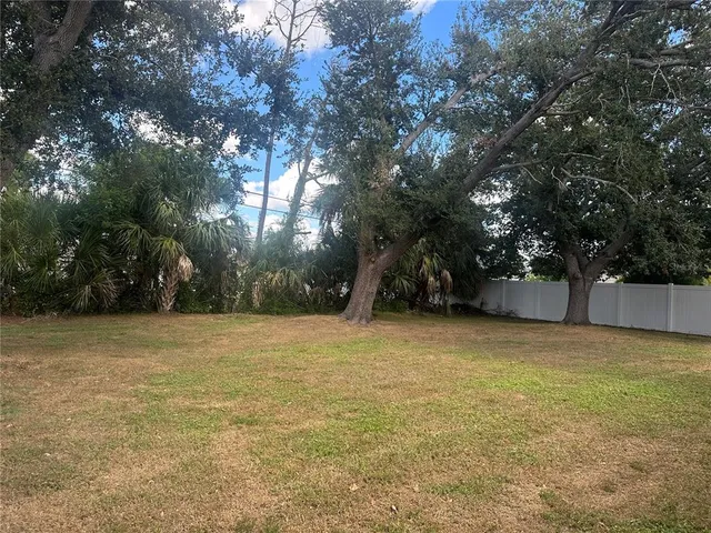 a view of a field with trees in front of house