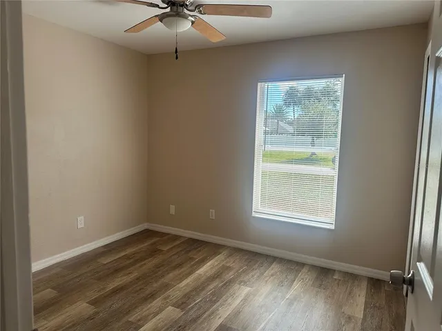 an empty room with a window and a fan