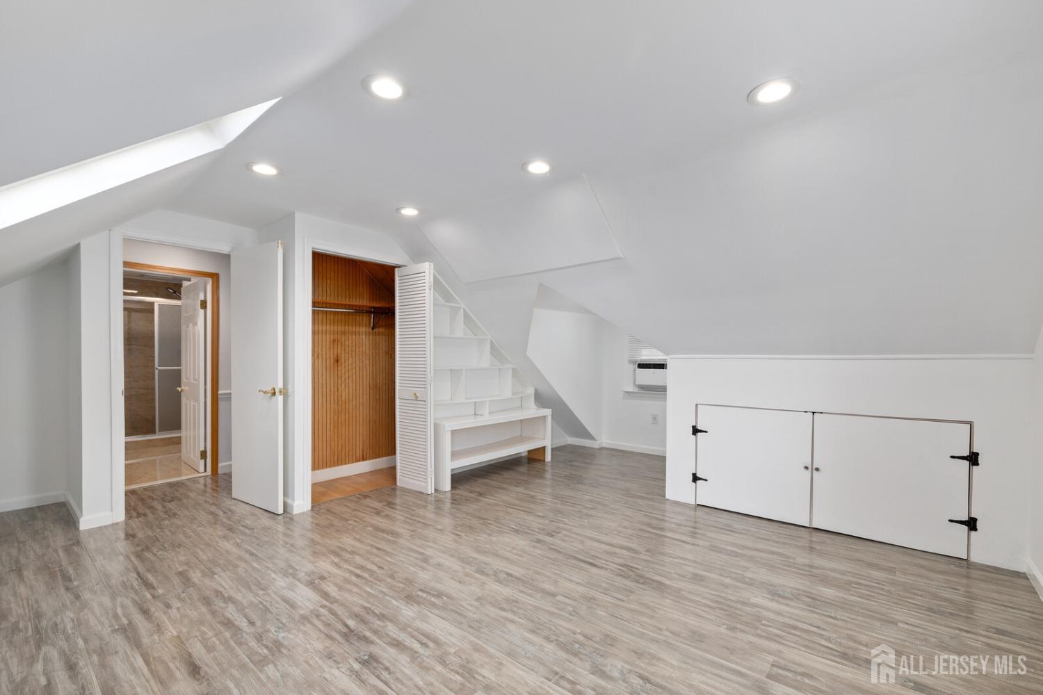 185 Plainfield Avenue Edison, NJ 08817 - Photo 20 of 30 an empty room with wooden floor and white doors