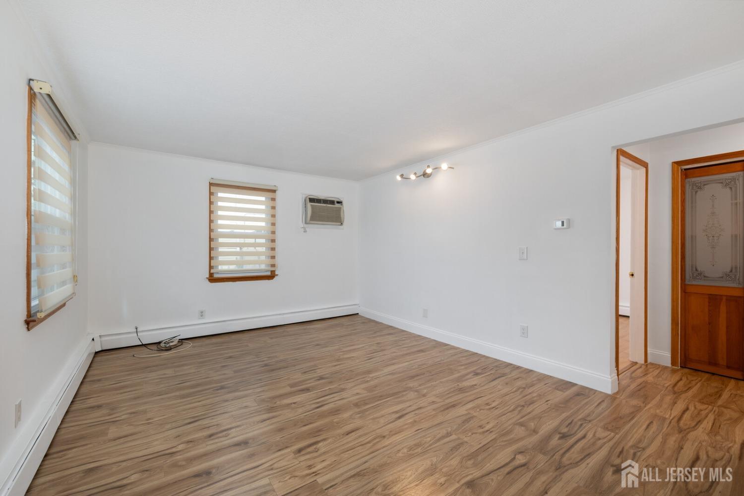 185 Plainfield Avenue Edison, NJ 08817 - Photo 6 of 30 an empty room with wooden floor and windows
