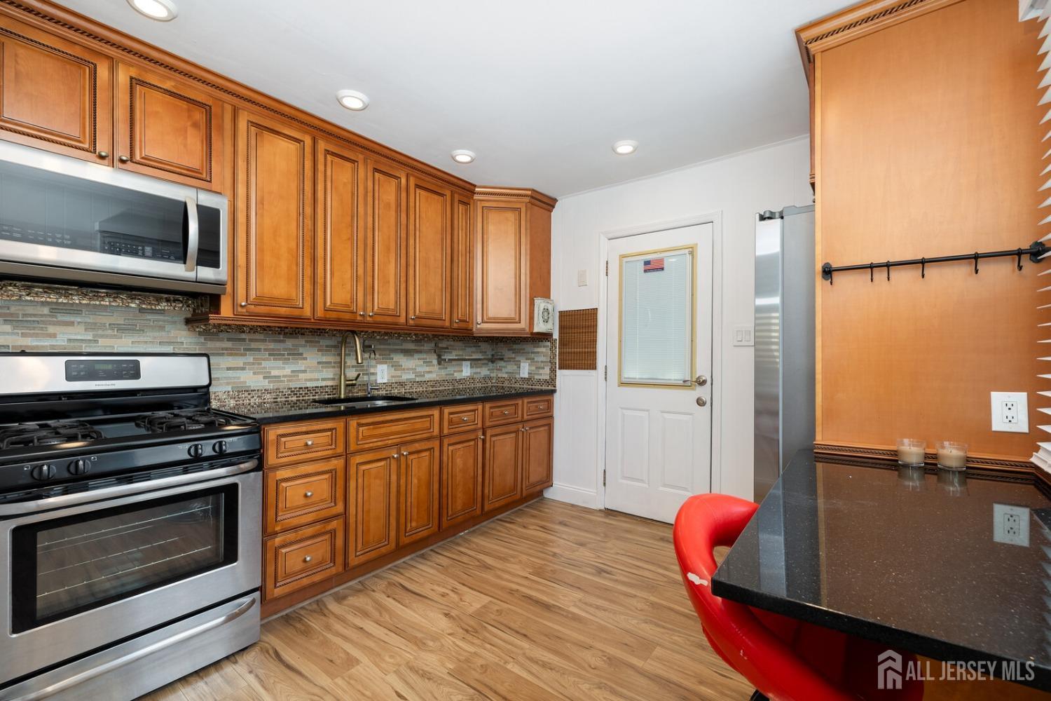 185 Plainfield Avenue Edison, NJ 08817 - Photo 9 of 30 a kitchen with stainless steel appliances granite countertop a stove a sink and a microwave