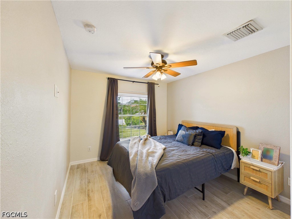 19694 Villa Rosa Loop Estero, FL 33967 - Photo 15 of 28 a bedroom with a bed and a chandelier
