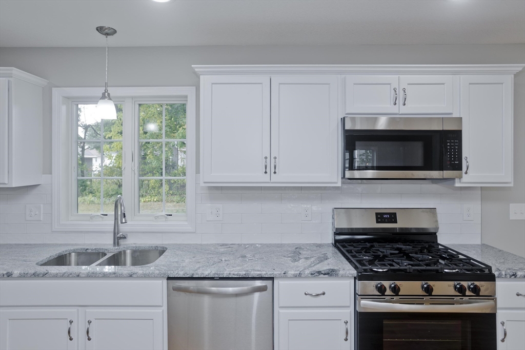 82 Judson Street Springfield, MA 01104 - Photo 8 of 38 a kitchen with granite countertop white cabinets and a stove top oven