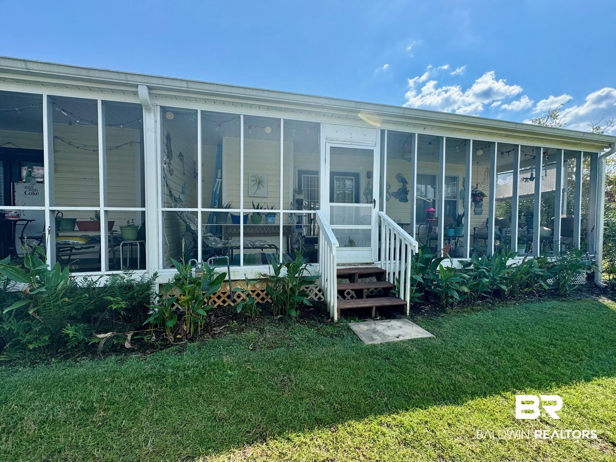 3200 Loop Road, Unit 55 Orange Beach, AL 36561 - Photo 32 of 40 Rear view of house featuring a yard and a sunroom