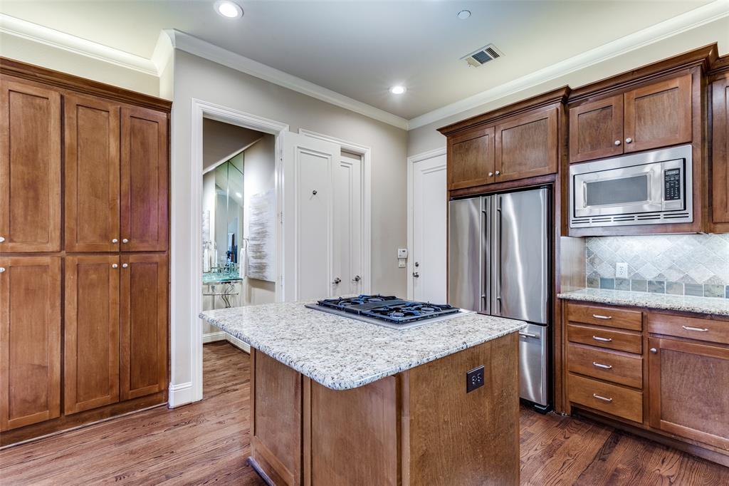 14725 Stanford Court Addison, TX 75254 - Photo 7 of 25 a kitchen with granite countertop wooden cabinets and a refrigerator