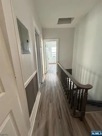 a view of a hallway with wooden floor and staircase