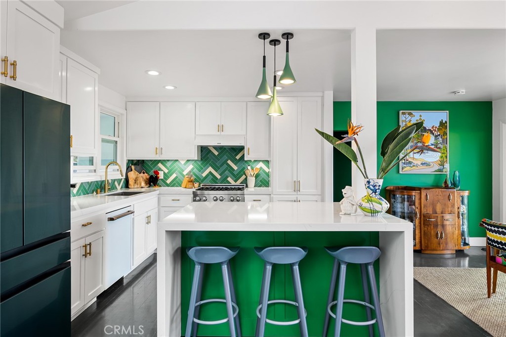a kitchen with cabinets a center island and appliances