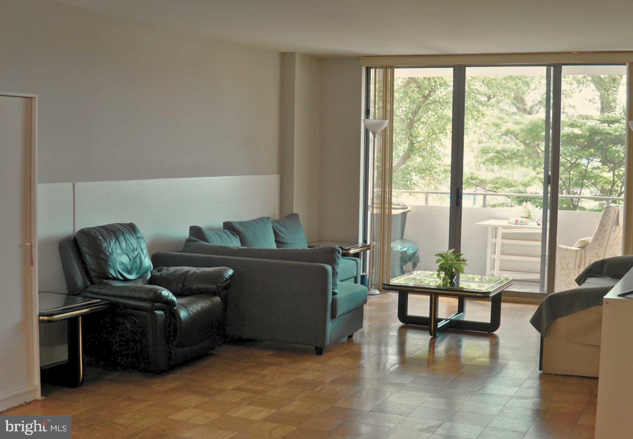 5101 River Road, Unit 405 Bethesda, MD 20816 - Photo 5 of 20 a living room with furniture and a floor to ceiling window