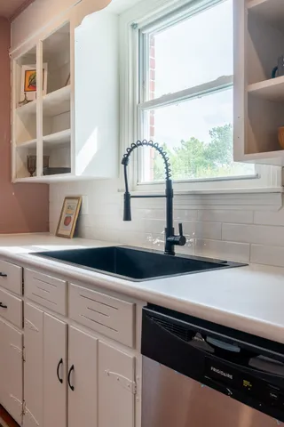 a kitchen with a sink a window and cabinets