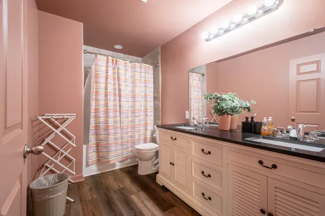 a spacious bathroom with a double vanity sink a mirror and a toilet