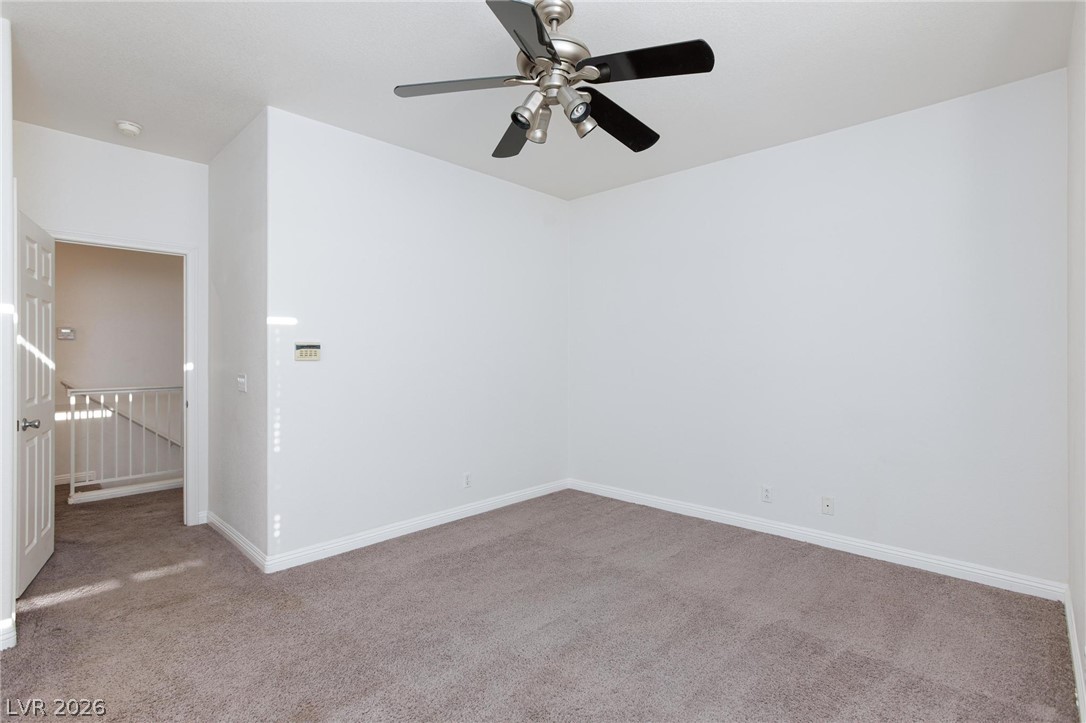 2246 Ramsgate Drive Henderson, NV 89074 - Photo 16 of 36 A spacious room offers comfortable carpet flooring and a ceiling fan for year-round comfort.