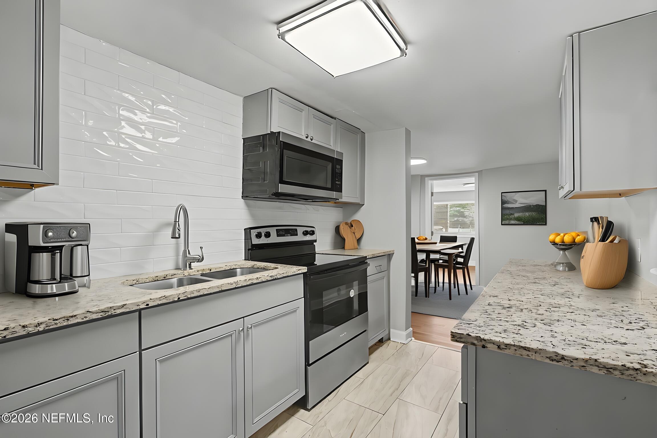 2625 Kohn Road Jacksonville, FL 32210 - Photo 7 of 34 a kitchen with a sink and a stove top oven