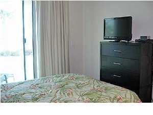 1110 Santa Rosa Boulevard, Unit B100 Fort Walton Beach, FL 32548 - Photo 22 of 27 a bedroom with a bed and a flat screen tv