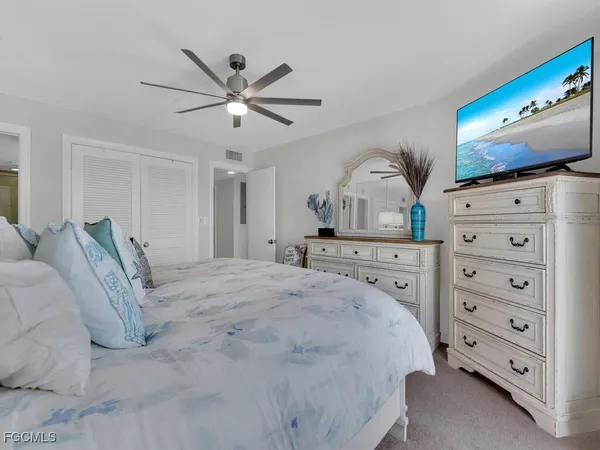 a spacious bedroom with a bed a dresser and a mirror