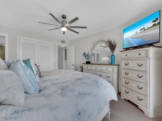 a spacious bedroom with a bed a dresser and a mirror