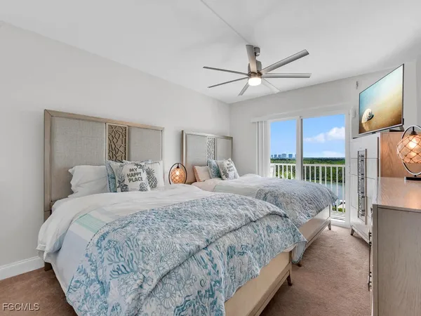 a bedroom with bed tv and a window