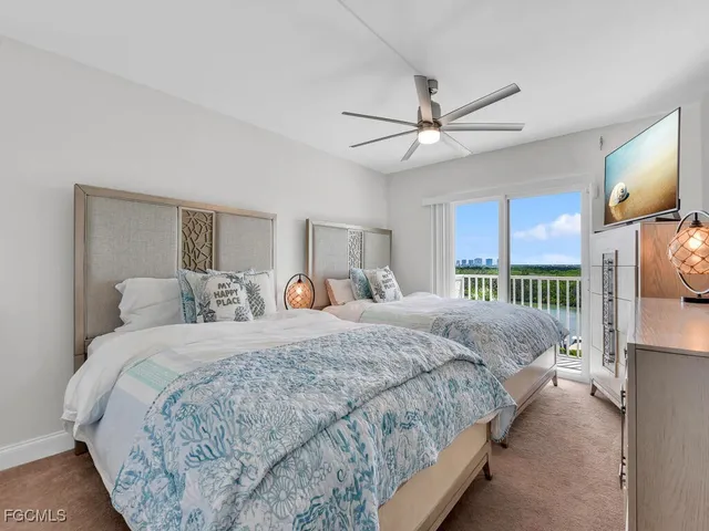 a bedroom with bed tv and a window