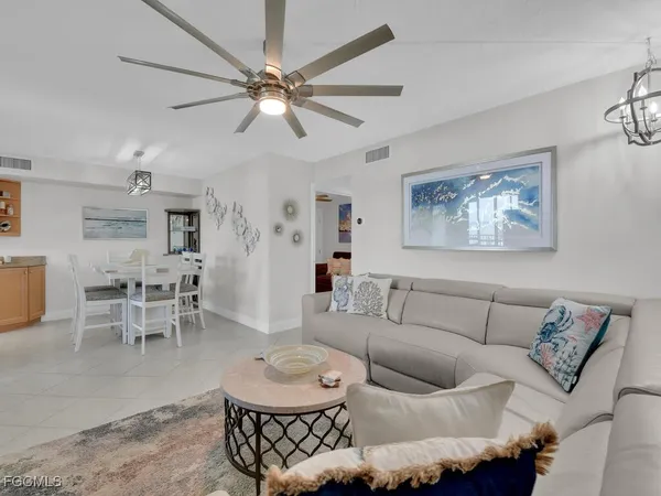 a living room with furniture a chandelier and a dining table