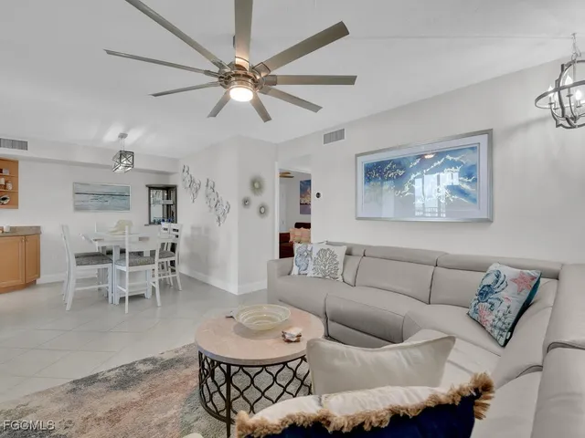 a living room with furniture a chandelier and a dining table