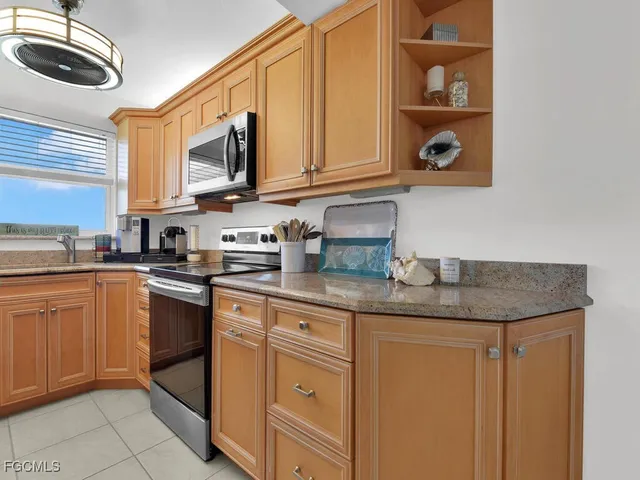 a kitchen with stainless steel appliances granite countertop a sink dishwasher stove and cabinets with wooden floor