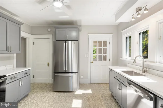 a kitchen with a sink refrigerator and microwave