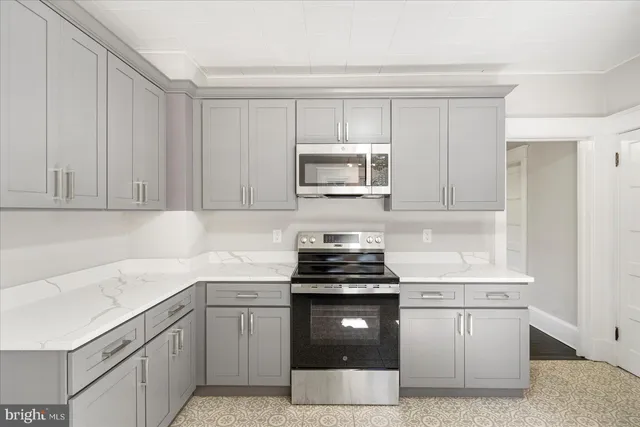 a kitchen with granite countertop white cabinets and stainless steel appliances
