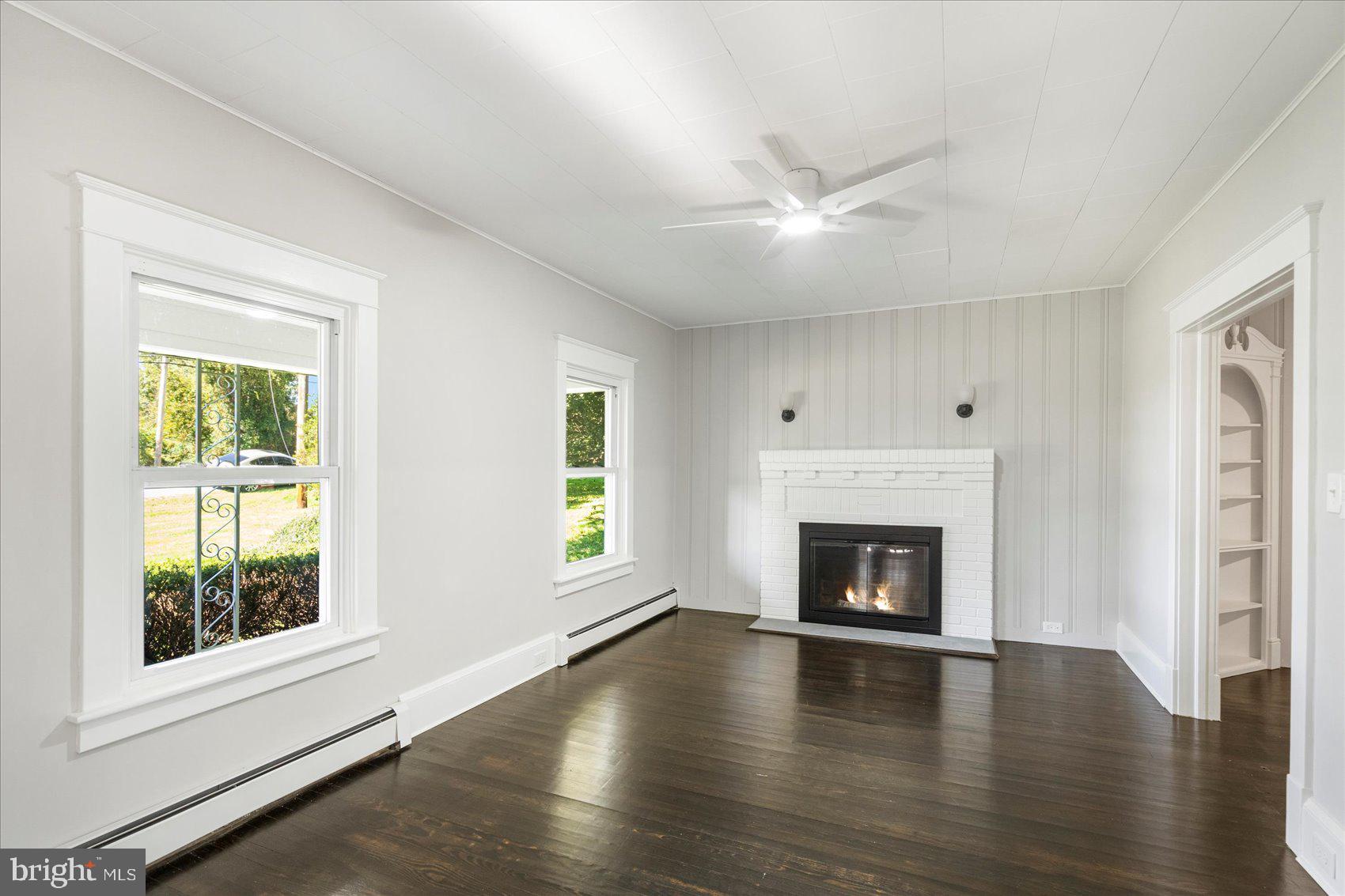 15317 York Road Sparks Glencoe, MD 21152 - Photo 2 of 47 an empty room with fireplace wooden floor and windows