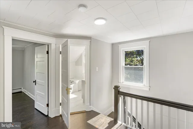 a view of a hallway with wooden floor and a cabinet