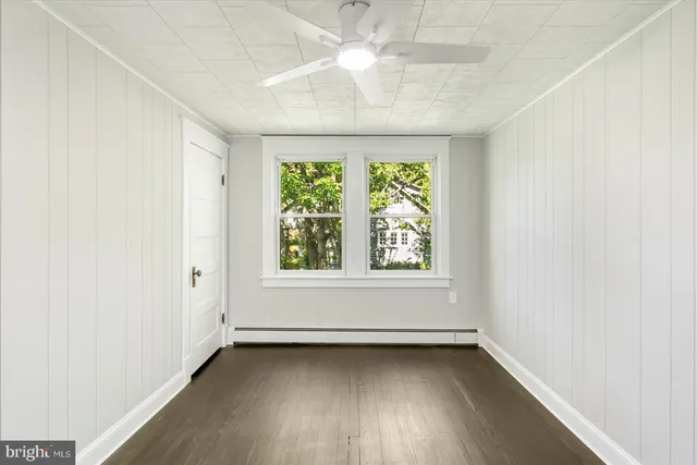 an empty room with a window and a ceiling fan