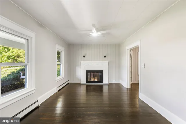 a view of an empty room with a window and fireplace