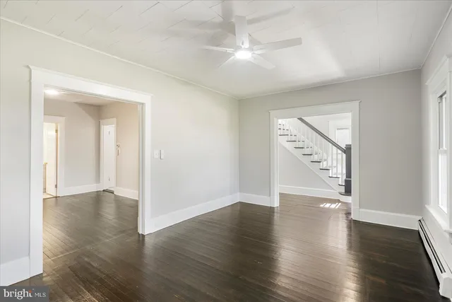 an empty room with wooden floor and mirror