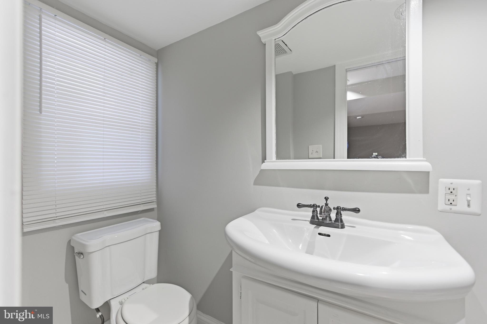 5518 13th Street Northwest, Unit B Washington, DC 20011 - Photo 8 of 8 a bathroom with a sink a toilet and mirror