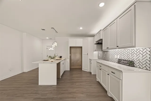 a kitchen with white cabinets appliances and sink