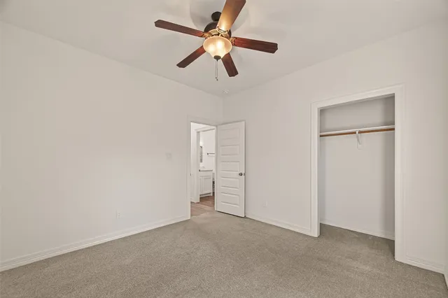 an empty room with closet and fan