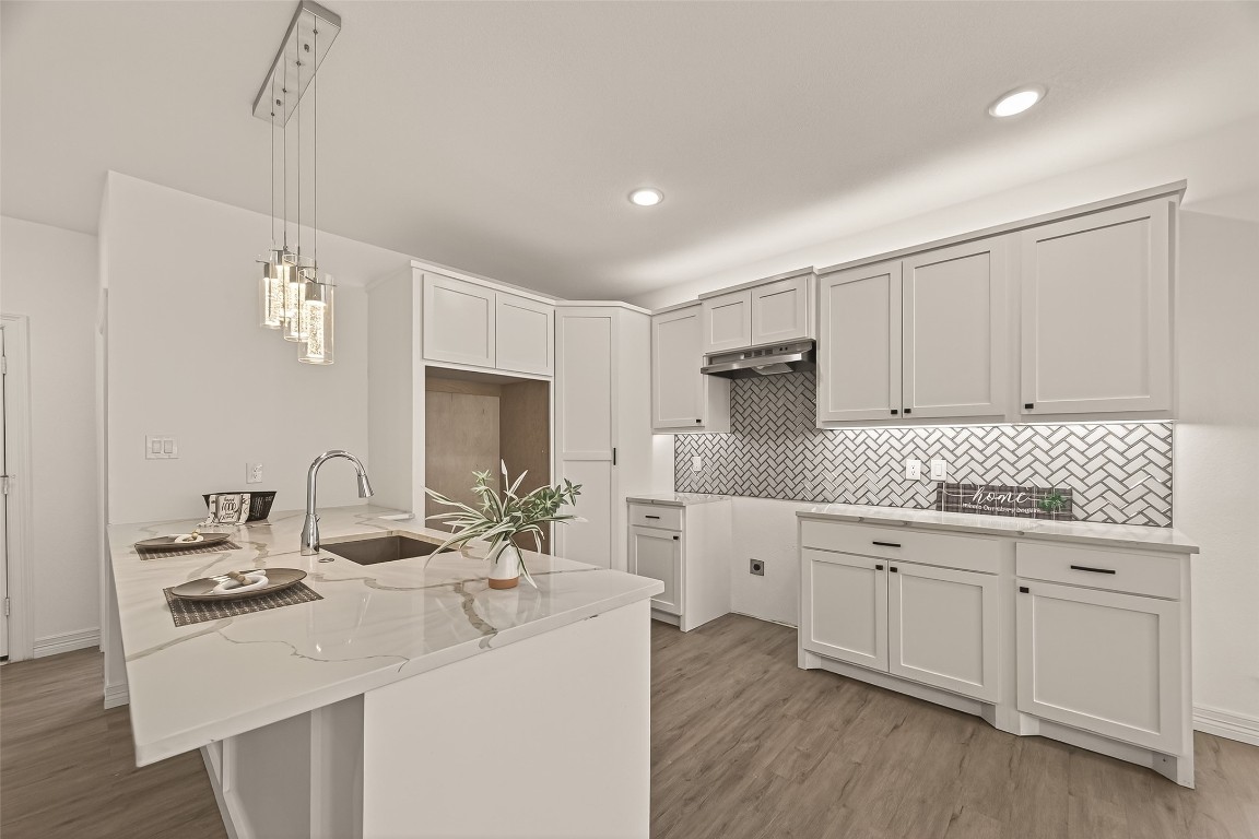 2609 Boss Street La Marque, TX 77568 - Photo 10 of 33 a kitchen with white cabinets a sink dishwasher and a stove with wooden floor