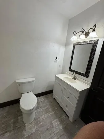 a bathroom with a toilet sink and mirror