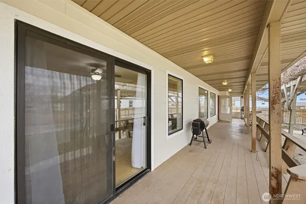 a view of a patio with table and chairs with wooden floor and fence